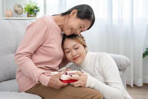 Mutter Tag, süß asiatisch Teen Mädchen umarmen reifen Mitte Alter Mama. Liebe, Kuss, Pflege, glücklich Lächeln genießen Familie Zeit. feiern Besondere Gelegenheit, glücklich Geburtstag, fröhlich Weihnachten. Besondere Tag foto