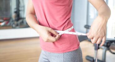 Ernährung und Diät. Schönheit schlanker weiblicher Körper mit Maßband. frau in trainingskleidung erreicht gewichtsverlustziel für ein gesundes leben, verrückt nach dünnheit, dünner taille, ernährungsberaterin. foto