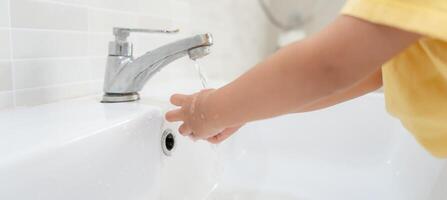 wenig Kind Hände waschen mit Seife Luftblasen und spülen mit sauber Wasser zu verhindern und halt das Verbreitung von Keime nach zurück zu heim, Virus oder COVID-19. gut Gesundheit und gut persönlich Hygiene, Virus, Bakterien foto