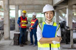 Mannschaft von asiatisch Ingenieur im voll Sicherheit Ausrüstung ist inspizieren Innerhalb das Gebäude Struktur zum Ermittlung Über Spezifikation auf Konstruktion Seite? ˅ Industrie und Qualität Steuerung Verwendungszweck foto