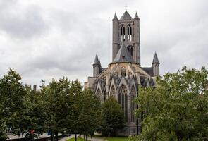 Herbst Aussicht von Heilige Nikolaus' Kirche im Gent gerahmt durch ein beschwingt Baum mit golden Blätter foto