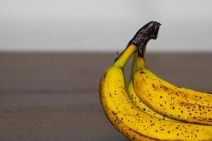 reif Banane Bündel mit dunkel Flecken auf Tabelle 3 foto