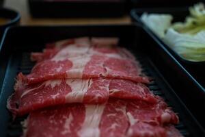 schließen oben Schuss von Selten geschnitten Rindfleisch mit marmoriert Textur auf ein schwarz Platte. foto