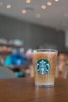 Bangkok, Thailand - - Januar 13, 2024 Kaffee Erfrischer Getränk serviert auf Kristall Glas mit Starbucks Logo gegen Kaffee Geschäft verwischen Hintergrund. foto