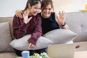 entspannt jung asiatisch Frau genießen Entspannung auf ein bequem Sofa beim heim. das schön Mädchen ruhig entspannt sich und atmet frisch Luft im das Haus. Uhr Filme und Sozial Netzwerke. foto