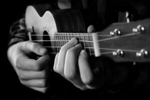 schließen oben von Mann Hand spielen Ukulele Gitarre foto