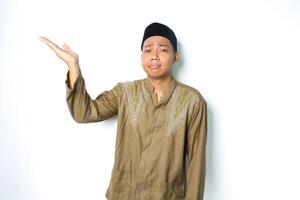 asiatisch Muslim Mann präsentieren zu neben mit betont Ausdruck isoliert auf Weiß Hintergrund foto