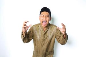 wütend asiatisch Muslim männlich schreiend mit greifen Hand suchen beim Kamera isoliert auf Weiß Hintergrund foto