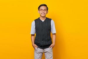 Porträt eines gutaussehenden asiatischen jungen Mannes, der auf gelbem Hintergrund in die Kamera schaut foto