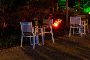 Stühle im Vorderseite von ein Straße Cafe im das Abend foto
