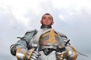 Ritter im Rüstung auf das Hintergrund von ein wolkig Himmel. foto