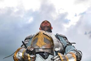 Ritter im Rüstung auf das Hintergrund von ein wolkig Himmel. foto