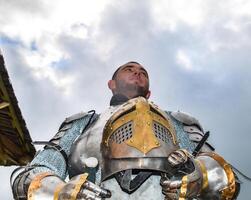 Ritter im Rüstung auf das Hintergrund von ein wolkig Himmel. foto