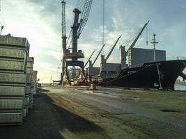 das Metall Stangen gefaltet auf das Hafen Seite? ˅ zum Export. vorübergehend Lager im das Hafen von roh Materialien. Hafen Ladung und Kräne. foto