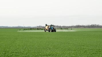 Traktor mit ein sprühen Gerät zum fein dispergiert Dünger. foto