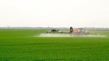 Traktor mit ein sprühen Gerät zum fein dispergiert Dünger. foto