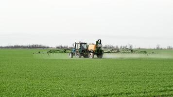 Traktor mit ein sprühen Gerät zum fein dispergiert Dünger. foto