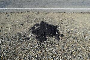 das Stück von frisch Asphalt welche fallen gelassen aus auf ein Straßenrand foto