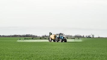 Traktor mit ein sprühen Gerät zum fein dispergiert Dünger. foto