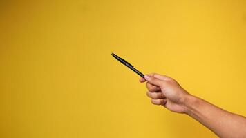 Hand von Mann halten Stift auf Gelb Hintergrund foto