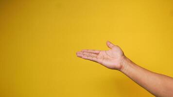 ein des Mannes Hand zeigt an ein Palme oben Geste auf ein Gelb Orange Hintergrund foto