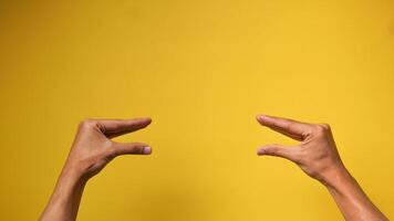 Herren Hände mit ein Geste von zwei Menschen reden auf ein Gelb Hintergrund foto