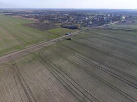 Traktor mit aufklappbar System von Sprühen Pestizide. düngen mit ein Traktor, im das bilden von ein Aerosol, auf das Feld von Winter Weizen. foto