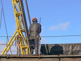 Arbeiter prüft das Ausrüstung auf das rig zum Entkernung foto