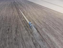 Anbau von Boden zum das Aussaat von Getreide. Traktor pflüge das Boden auf das Feld foto