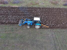 Traktor Pflügen das Garten. Pflügen das Boden im das Garten foto