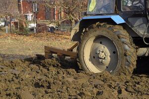 Traktor Pflügen das Garten. Pflügen das Boden im das Garten foto