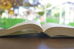 offenes buch und ein bleistift auf holztisch foto