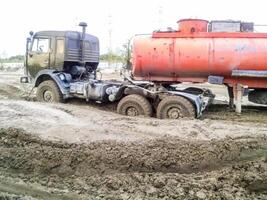 stecken LKW im Schlamm auf ein Schmutz Straße. foto