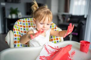 süß wenig Mädchen Gemälde mit Finger beim heim. kreativ Spiele zum Kinder. bleibe beim Zuhause Unterhaltung foto