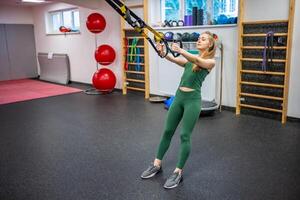 Ausbildung im das Fitnessstudio zum das Zahl Korrektur. jung Frau tun Fitness Übungen beim Fitnessstudio. foto