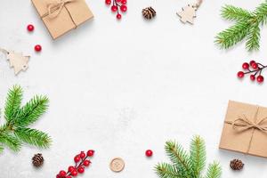 süßer Weihnachtshintergrund mit Geschenken, Zweigen und Dekorationen. freier Platz in der Mitte für Begrüßungstext foto
