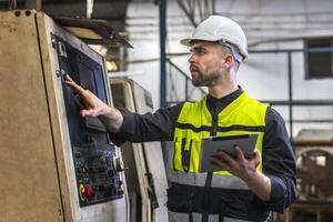 Ingenieur aussehen Projekte und Planung mit Tablette Handy, Mobiltelefon im Fabrik foto