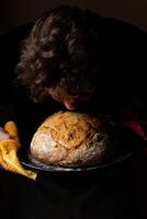 attraktiv jung kaukasisch Koch posieren mit Weiß Sauerteig Brot. foto