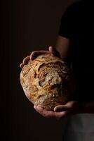 attraktiv jung kaukasisch Koch posieren mit Weiß Sauerteig Brot. foto