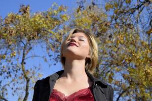 ein Frau ist posieren im Vorderseite von ein Kamera im ein Herbst Park. Herbst Foto schießen. Herbst im das Park