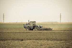 üppig und lösen das Boden auf das Feld Vor Aussaat. das Traktor pflüge ein Feld mit ein Pflug foto