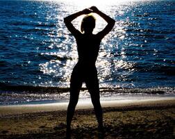 Silhouette von ein schön Mädchen Zahl auf das Hintergrund von das Meer beim Sonnenuntergang foto