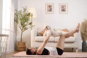 jung Frau im Sportbekleidung tun Meditation trainieren und Yoga mit süß Hund im Leben Zimmer, gesund Lebensstil, mental Gesundheit Konzept. foto