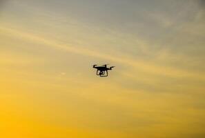 Quadrocopter Silhouette gegen das Hintergrund von das Sonnenuntergang foto