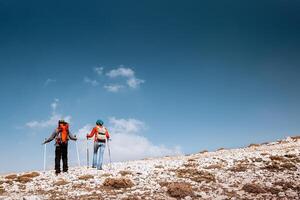 aktiv Paar Gehen mit Stöcke im das Berge foto