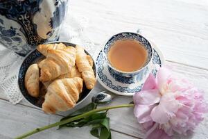 zart Frühling immer noch Leben mit Croissants und ein Strauß von Rosa Pfingstrosen foto