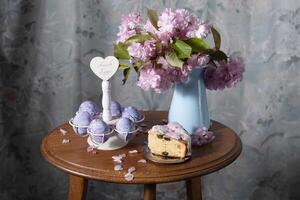 Ostern Kuchen und gemalt Eier und ein Strauß von Rosa Sakura Blumen auf ein Tabelle foto