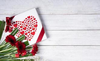 Valentinstag Tag Geschenk, rot Herz Praline Box und Blume Strauß auf Weiß Tabelle foto
