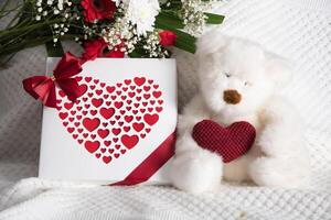 Valentinsgrüße Tag Geschenk, Teddy Bär mit ein Herz, ein Box von Pralinen und ein Strauß foto