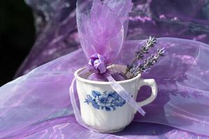 lila Lavendel Beutel im Jahrgang Tasse, Chiffon Tasche zum Aromatherapie, immer noch Leben foto